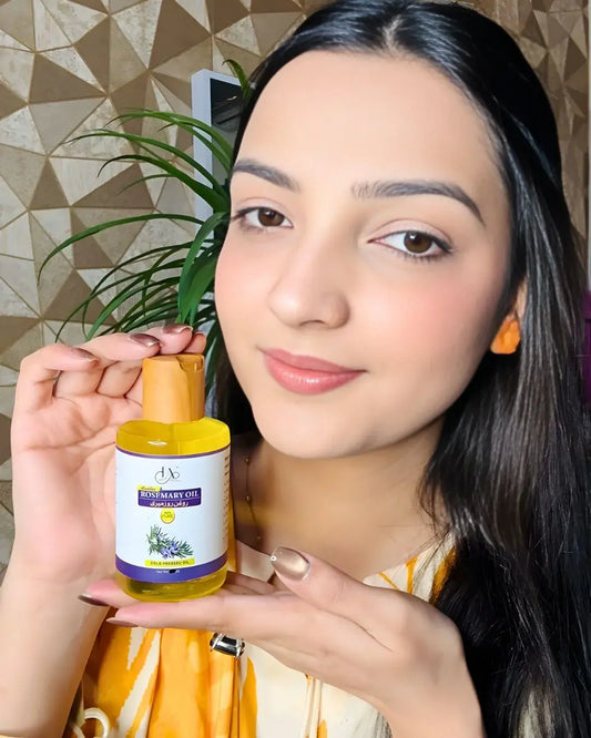 Just Amna rosemary oil bottle held by hand, wooden cap and label visible