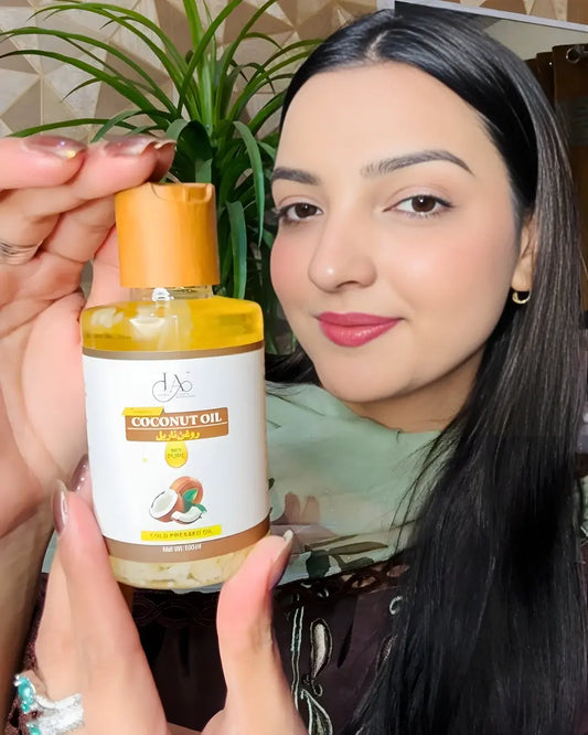 Just Amna coconut oil bottle with yellow cap and coconut graphic, 100ml cold pressed