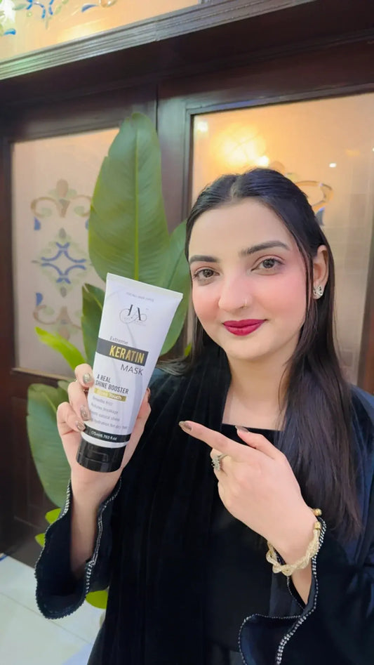 A woman presenting the Just Amna shine booster keratin hair mask.