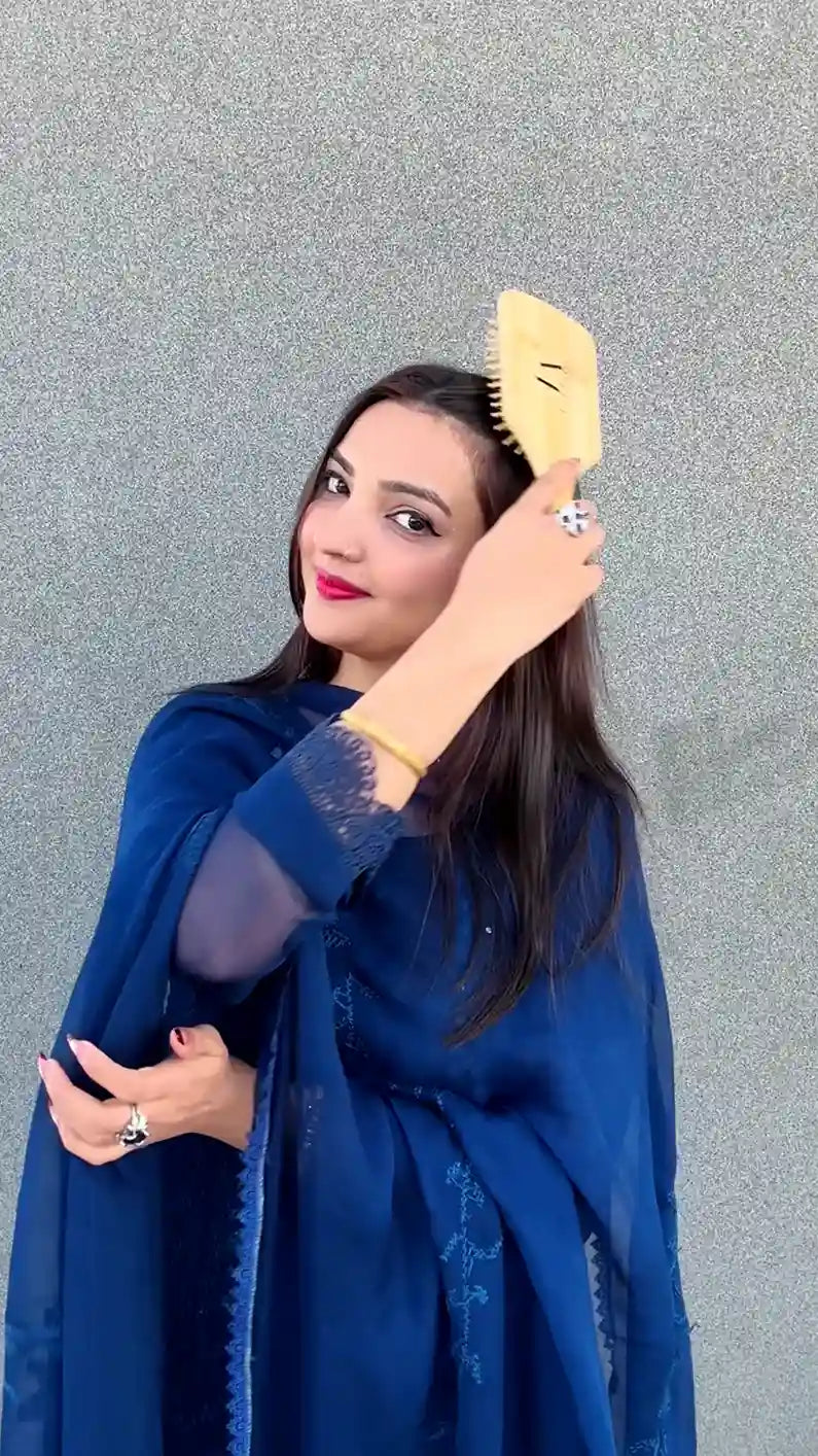Just Amna yellow hairbrush smoothing long dark hair, model in deep blue embroidered outfit
