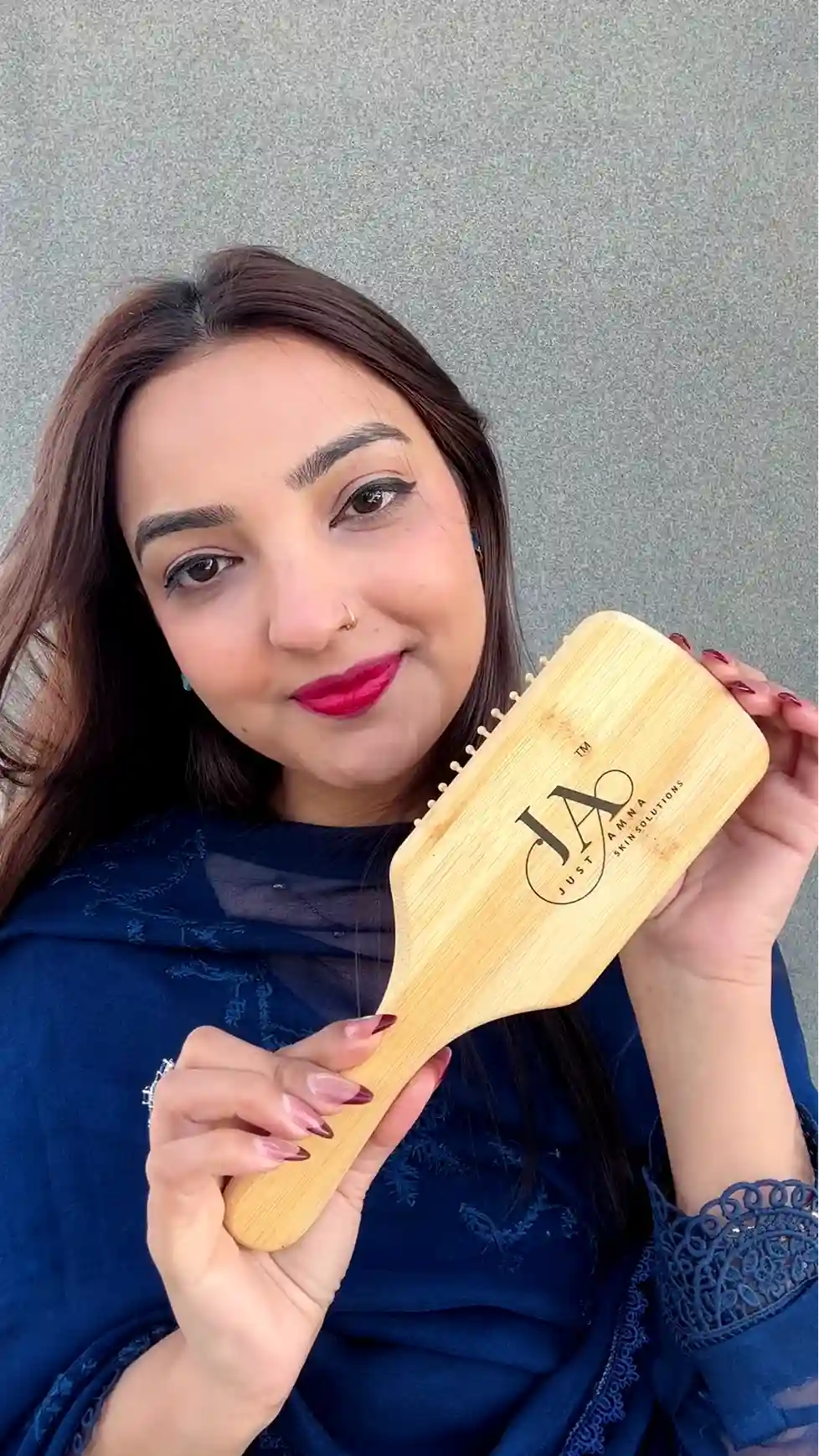 Just Amna engraved wooden brush for Hair Solutions, model in blue outfit