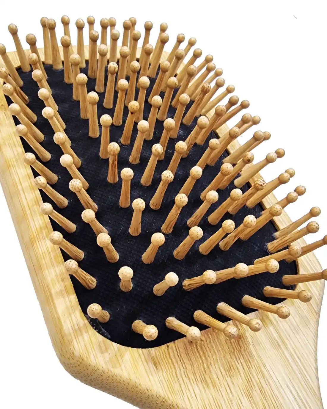 Just Amna wooden paddle brush close-up with rounded wooden bristles on black cushion