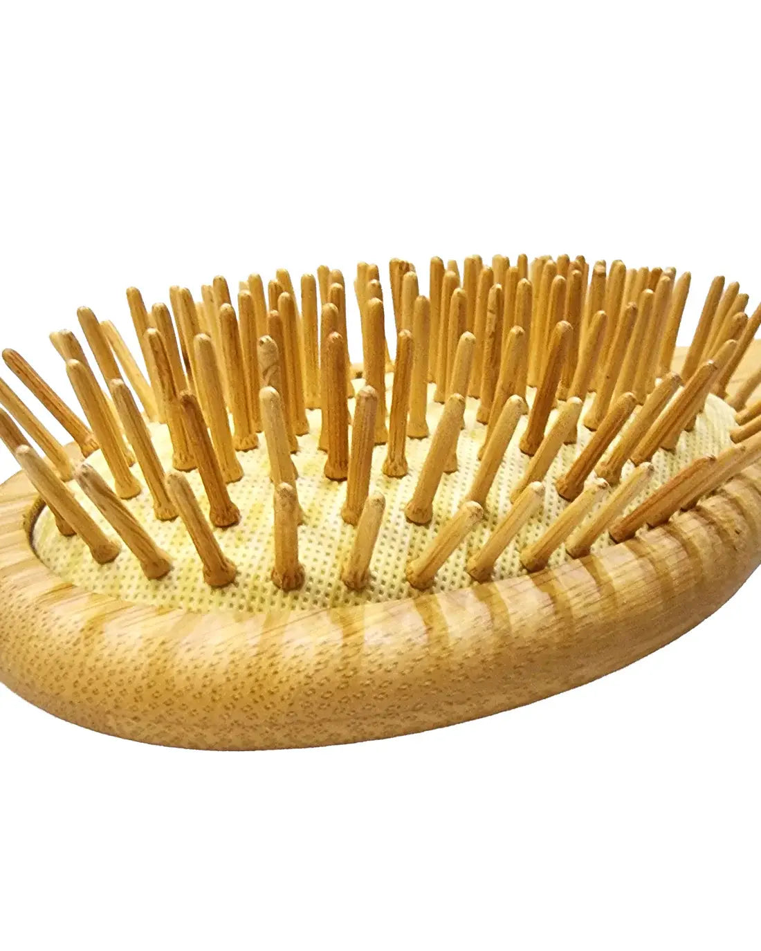 Angled view of Just Amna hair brush wooden bristles and cushion base.
