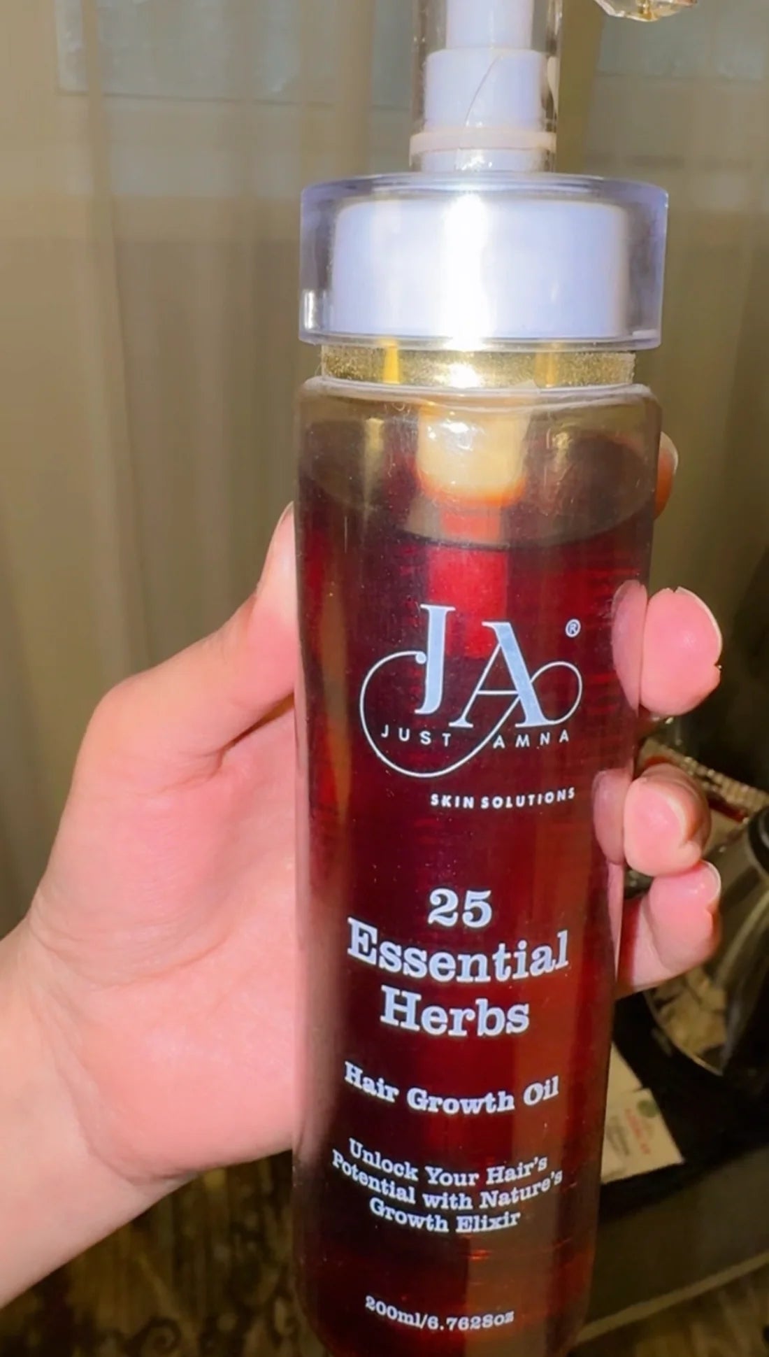 Close-up of Just Amna 25 Essential Herbs Hair Growth Oil herbal formula.
