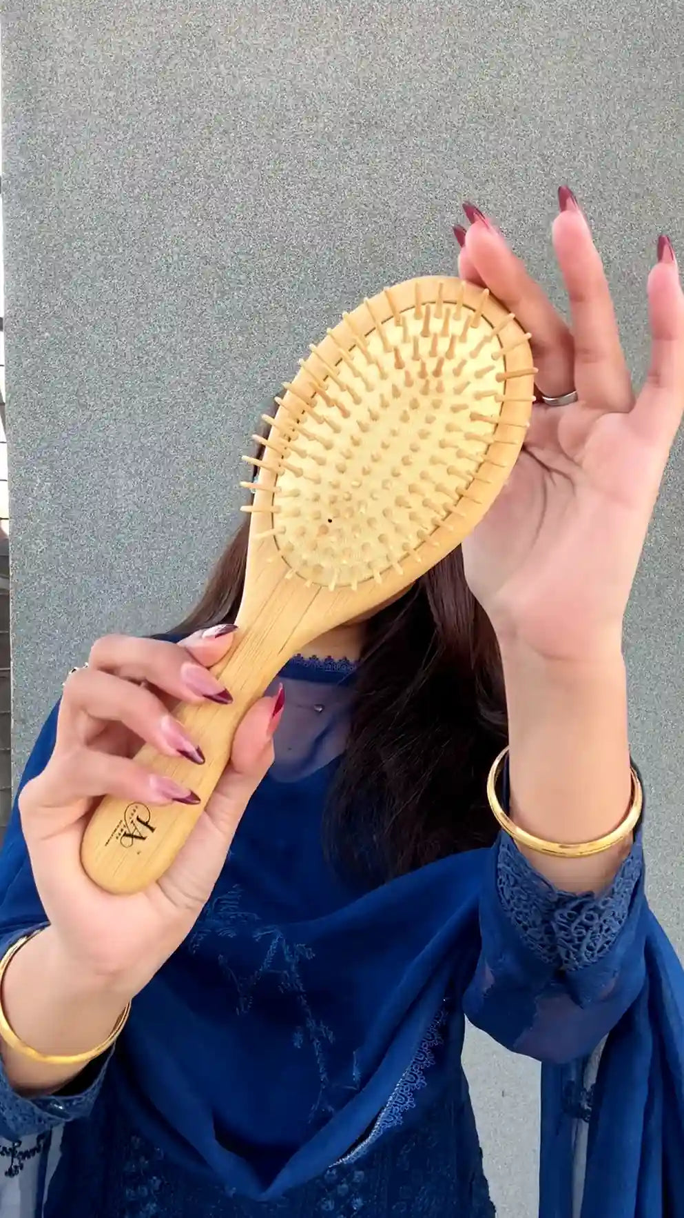 Close-up of Just Amna hair brush wooden bristles for scalp massage.